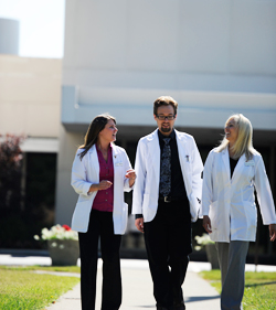 3 clinicians walking outside NUHS Whole Health Center Lombard