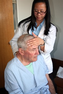 intern treating older patient in clinic