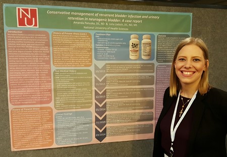 Dr. Amanda Bose stands beside the case study poster presented at DC2017.