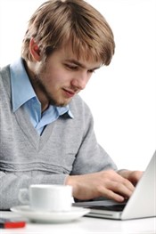 student on laptop with cup of coffee