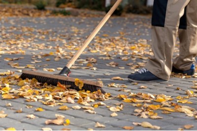 man sweeping leaves