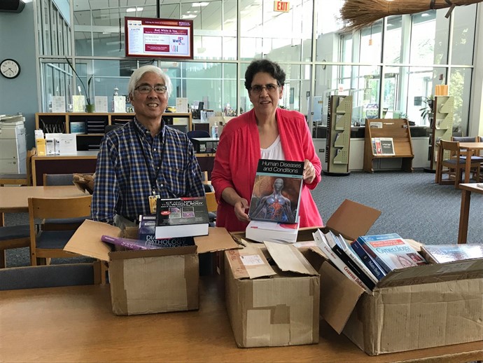 Russ Iwami, NUHS Reference Librarian, and staff with donated medical books