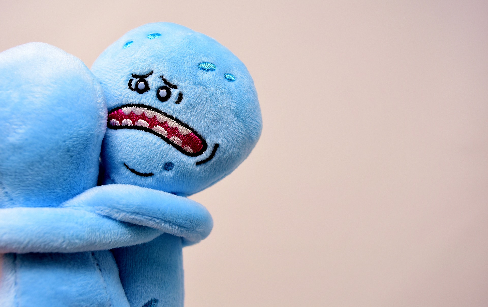 plush toys hugging with one having a sad face