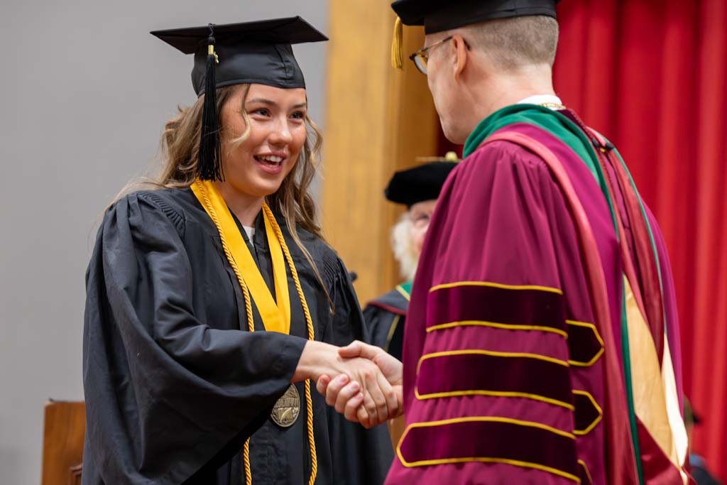 Graduate shakes hand with President Stifefel