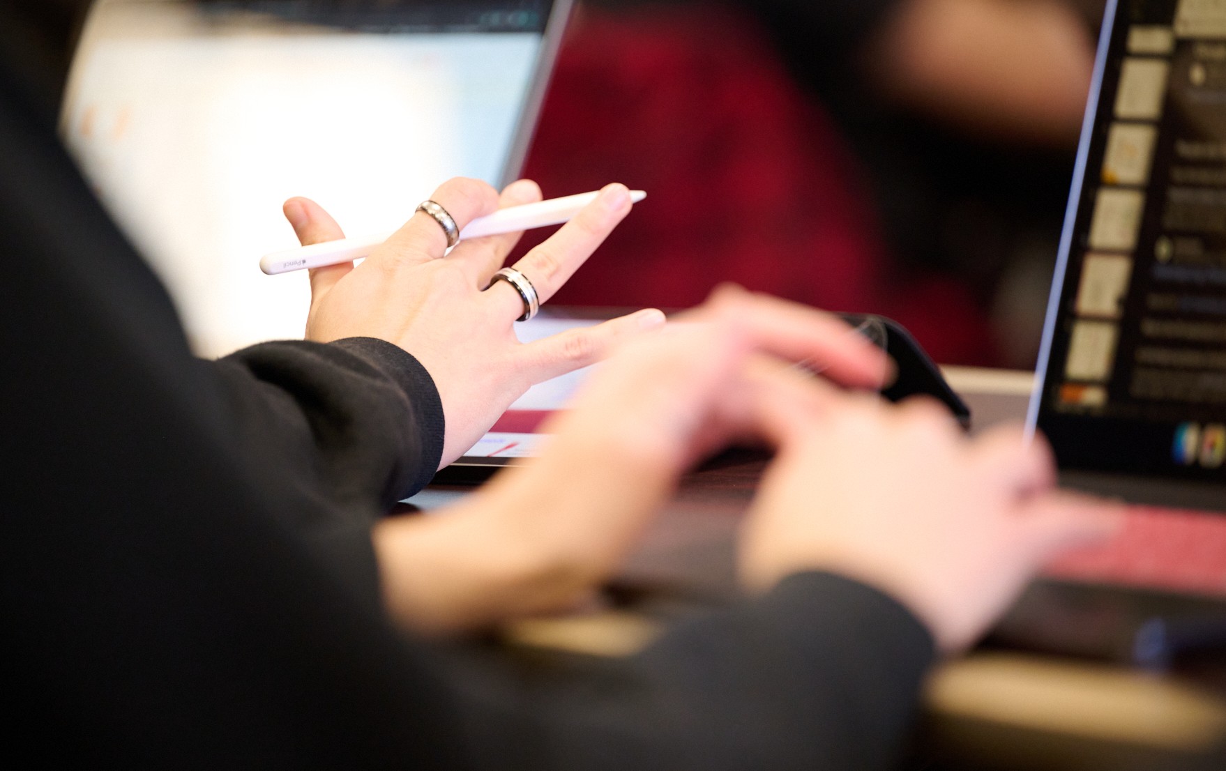 Busy student hands behind laptop screen taking exam