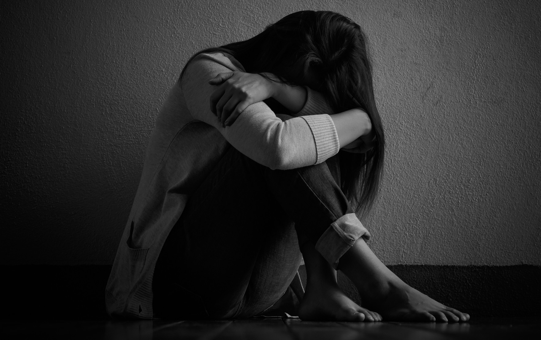 Black and white image of a sitting, depressed female patient