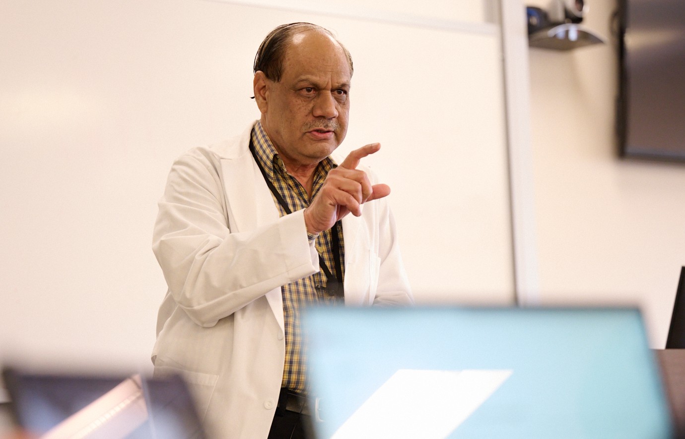 Dr. M.A. Khan conducting lecture behind podium