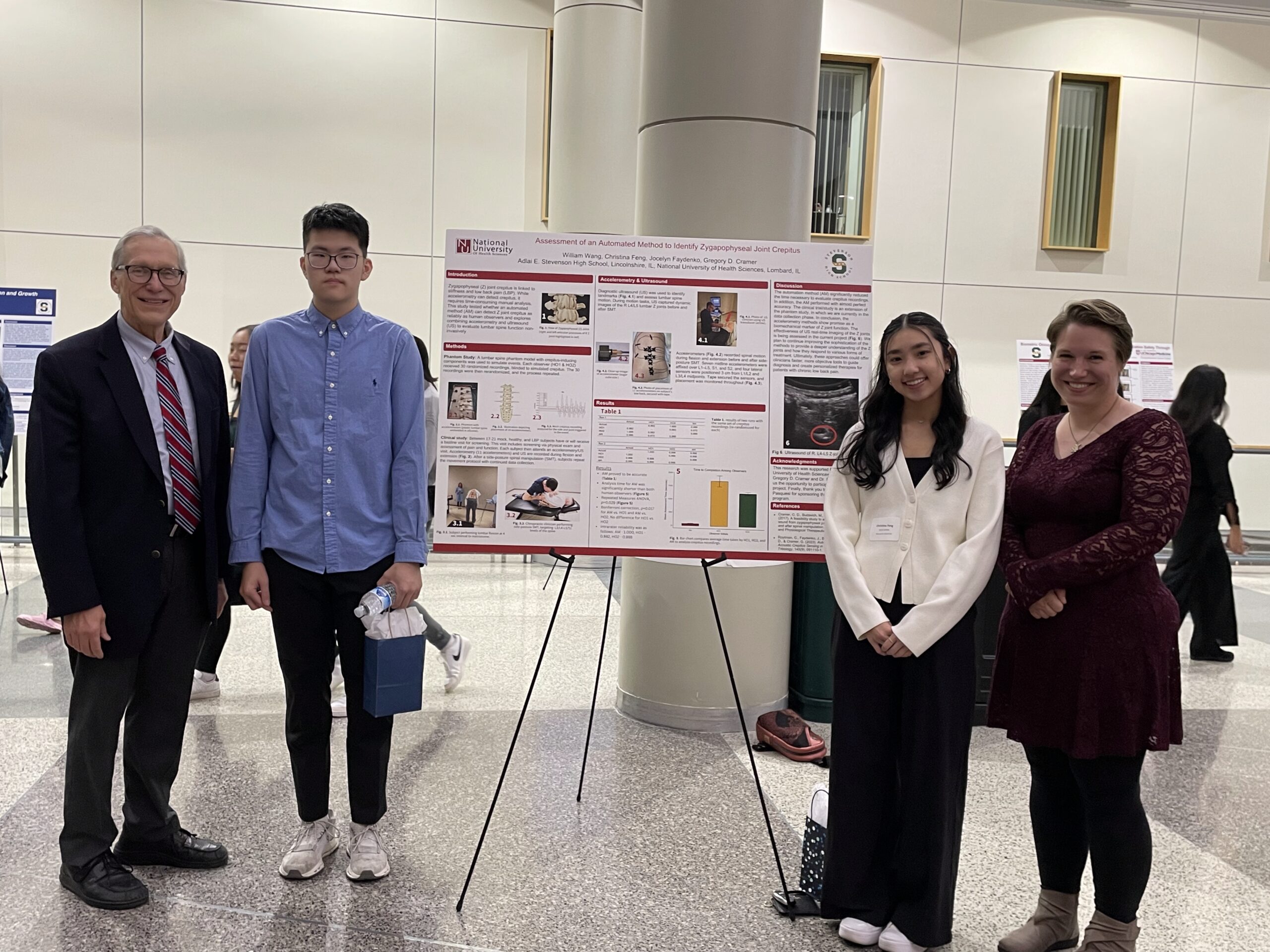 Dr. Cramer, Dr. Faydenko, William Weng and Christina Feng pose in front of their presentation board