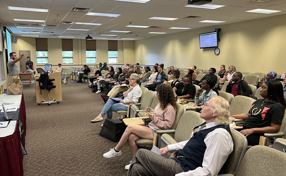 Dr. Maier presents in front of classroom full of students.