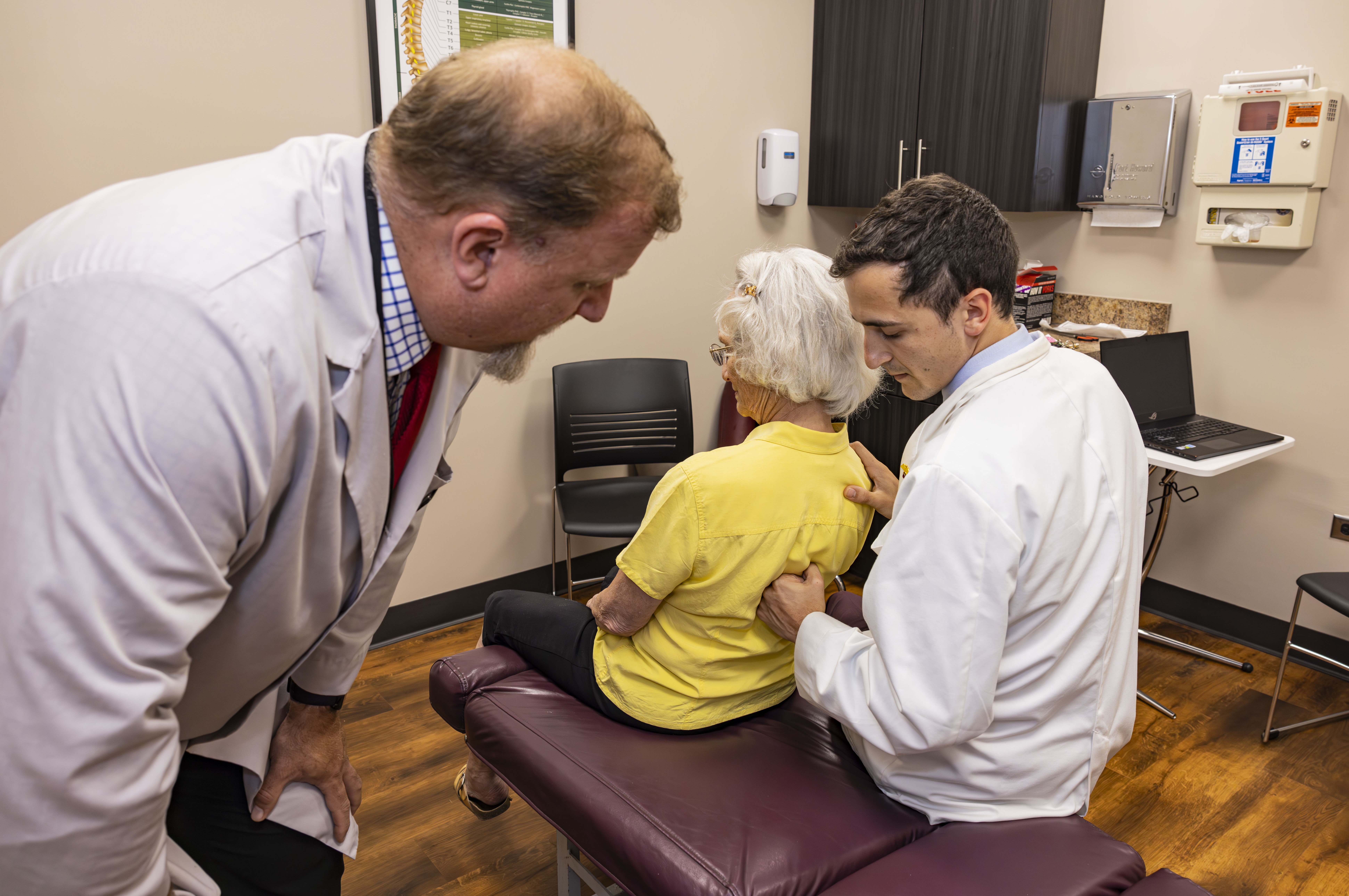 NUHS chief clinician, student and patient in chiropractic exam