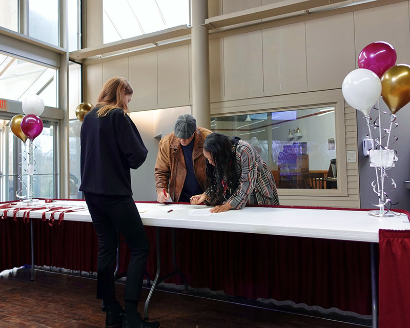 admissions staff checking in prospective students at a visit event