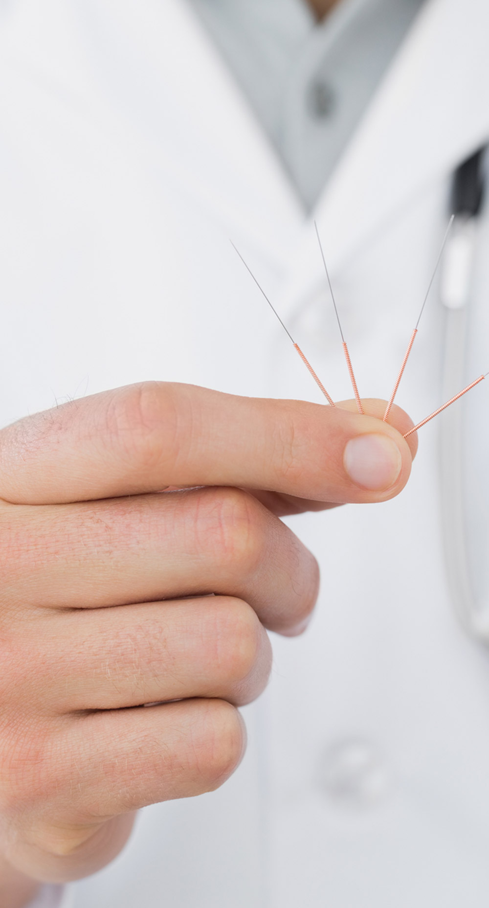 doctor of acupuncture holding acupuncture needles