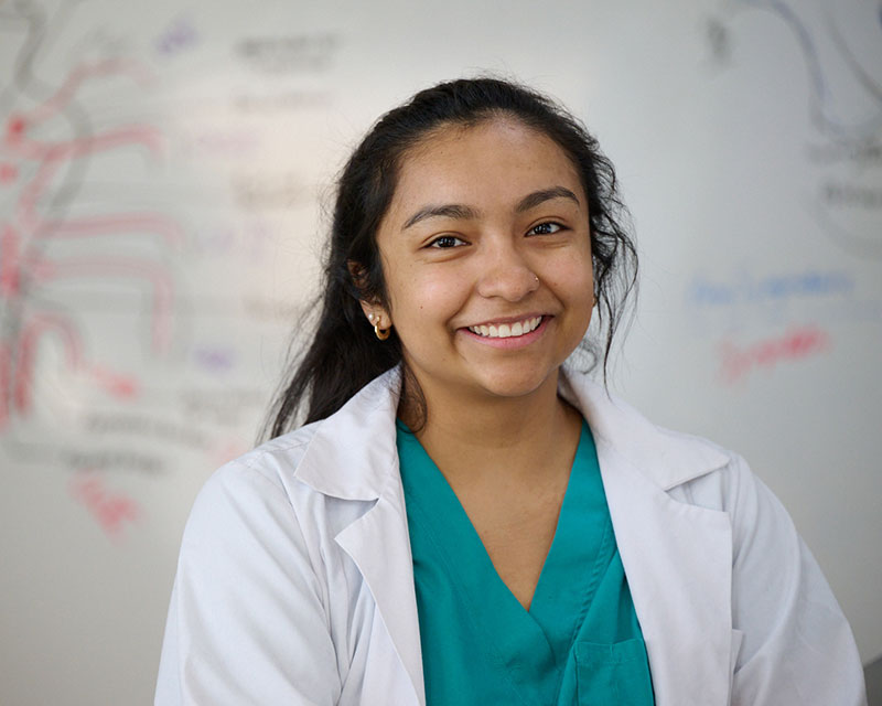 NUHS student standing in front of lecture notes on white board