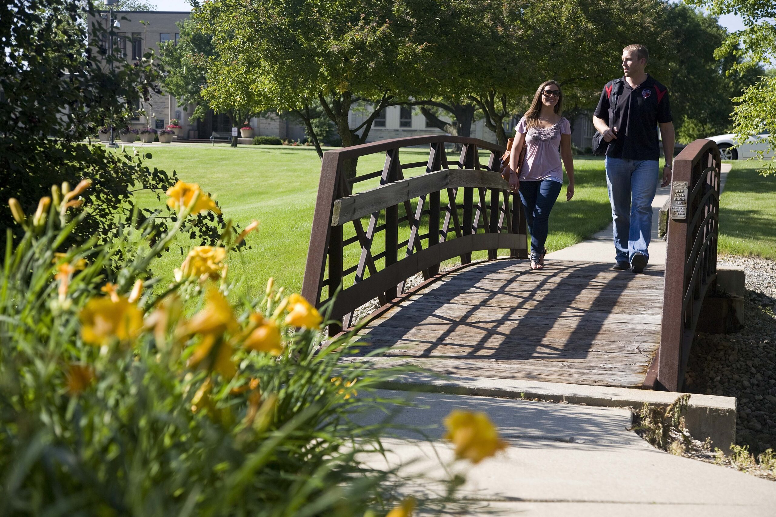 students visiting nuhs, walking across bridge on campus